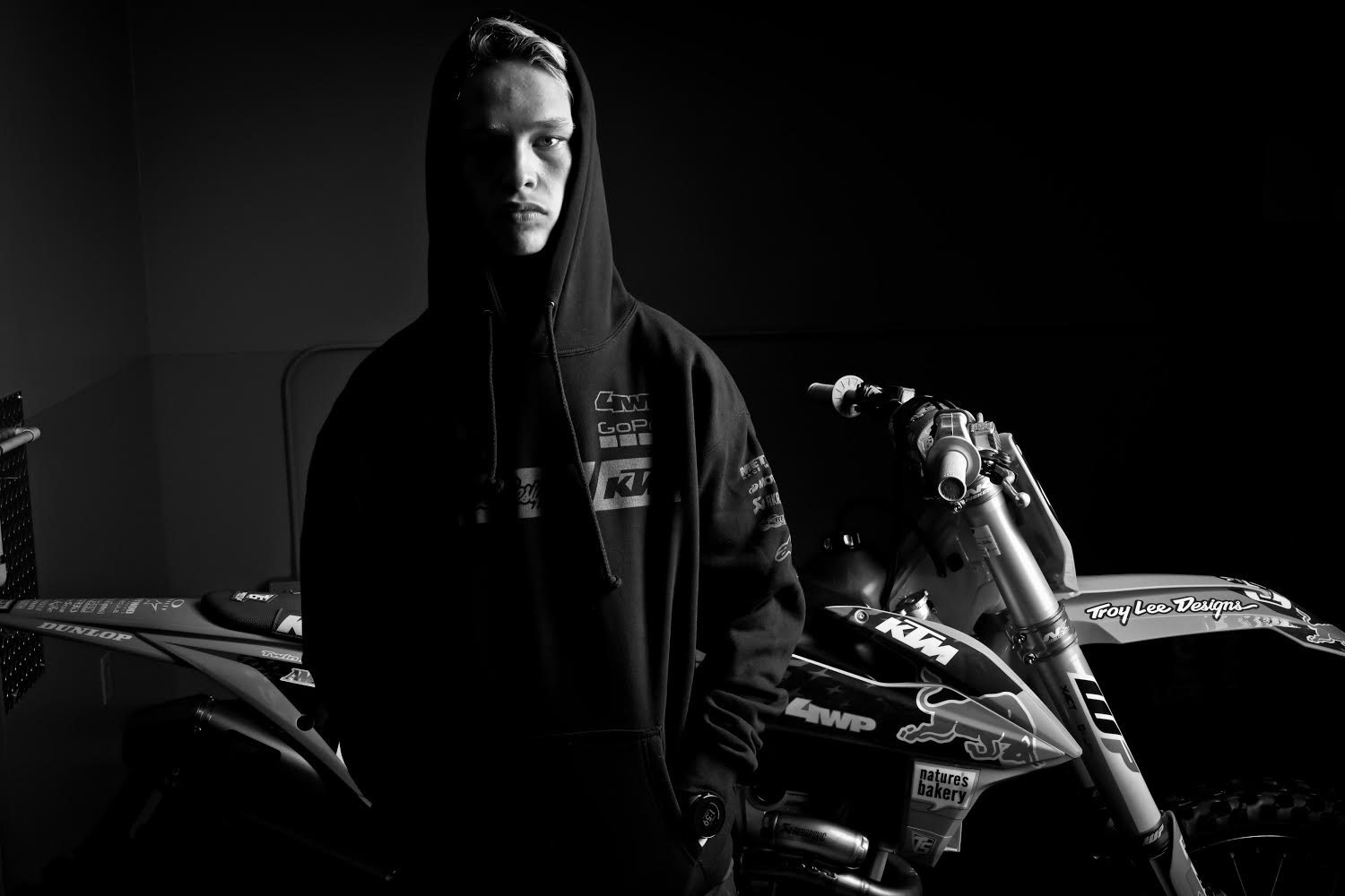 Brian Moreau debout devant sa KTM, en noir et blanc